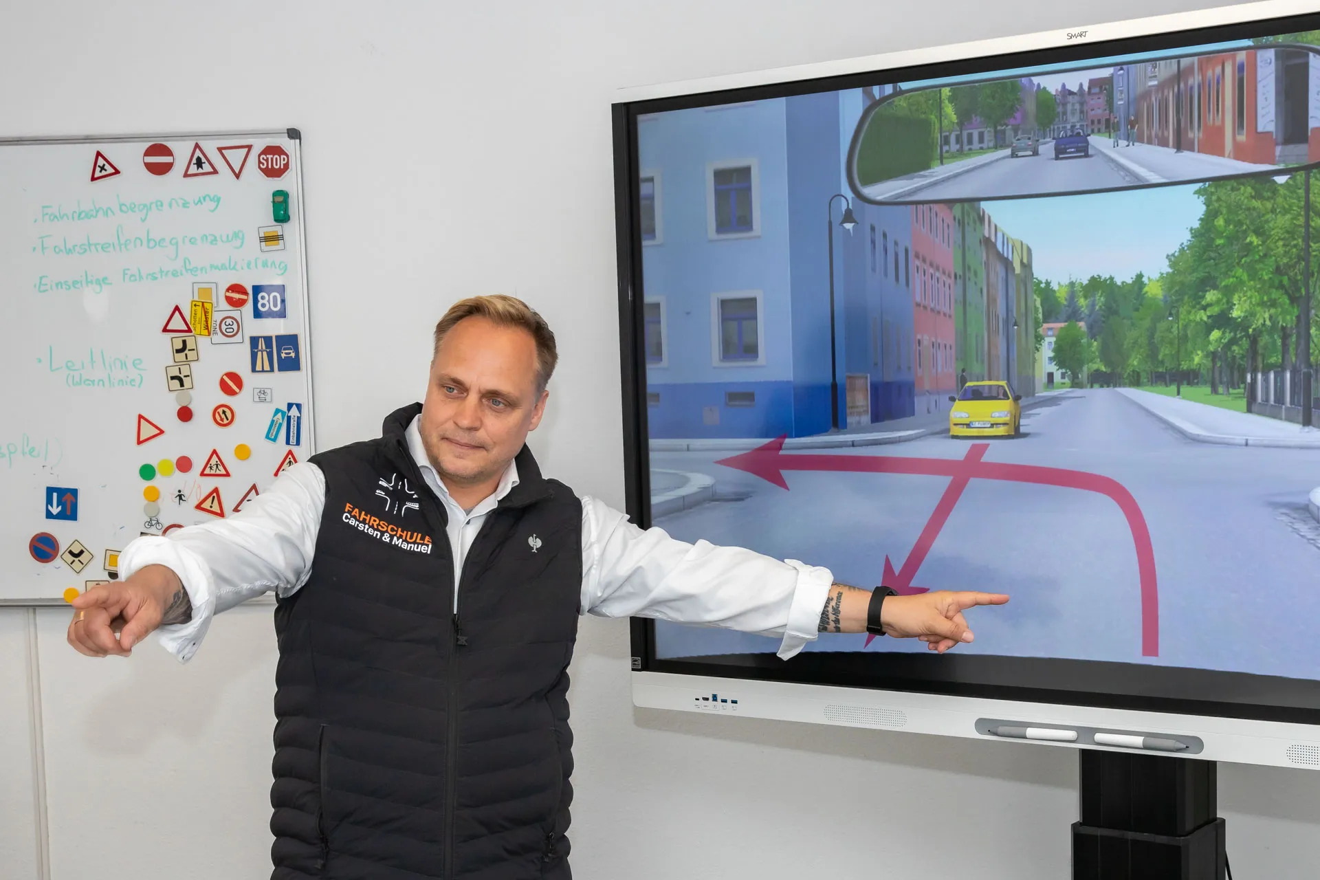 Fahrlehrer Carsten Zschäpe bei Theoriestunde vor Smartboard