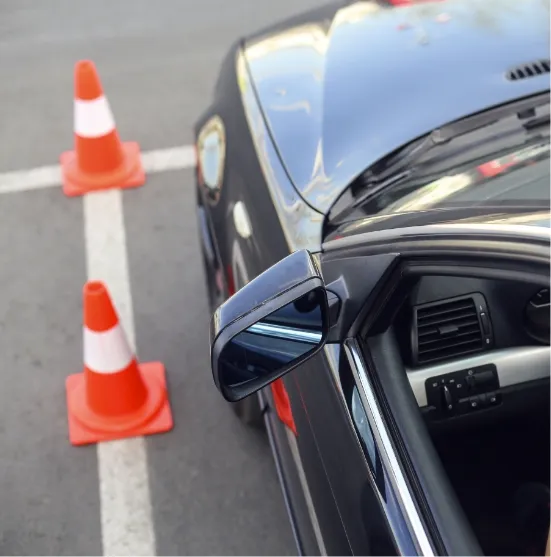 Fahrschulauto hat auf einem Parkplatz zwischen Pylonen eingeparkt