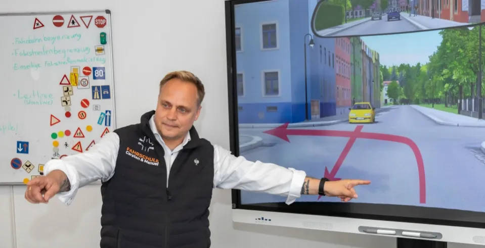 Fahrlehrer Carsten Zschäpe bei Theoriestunde vor Smartboard